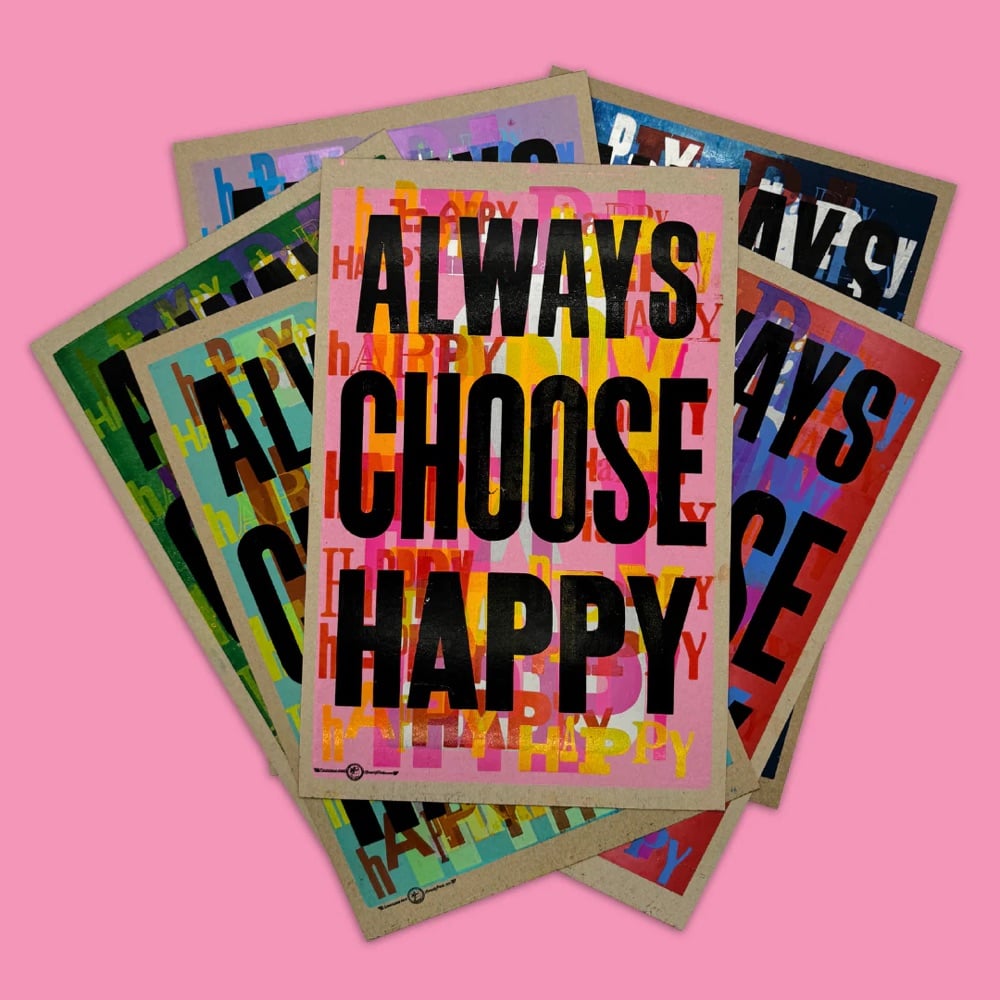 a stack of colorful prints that say 'Always Choose Happy'
