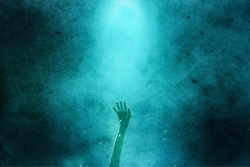 a hand raised, bathed in blue light