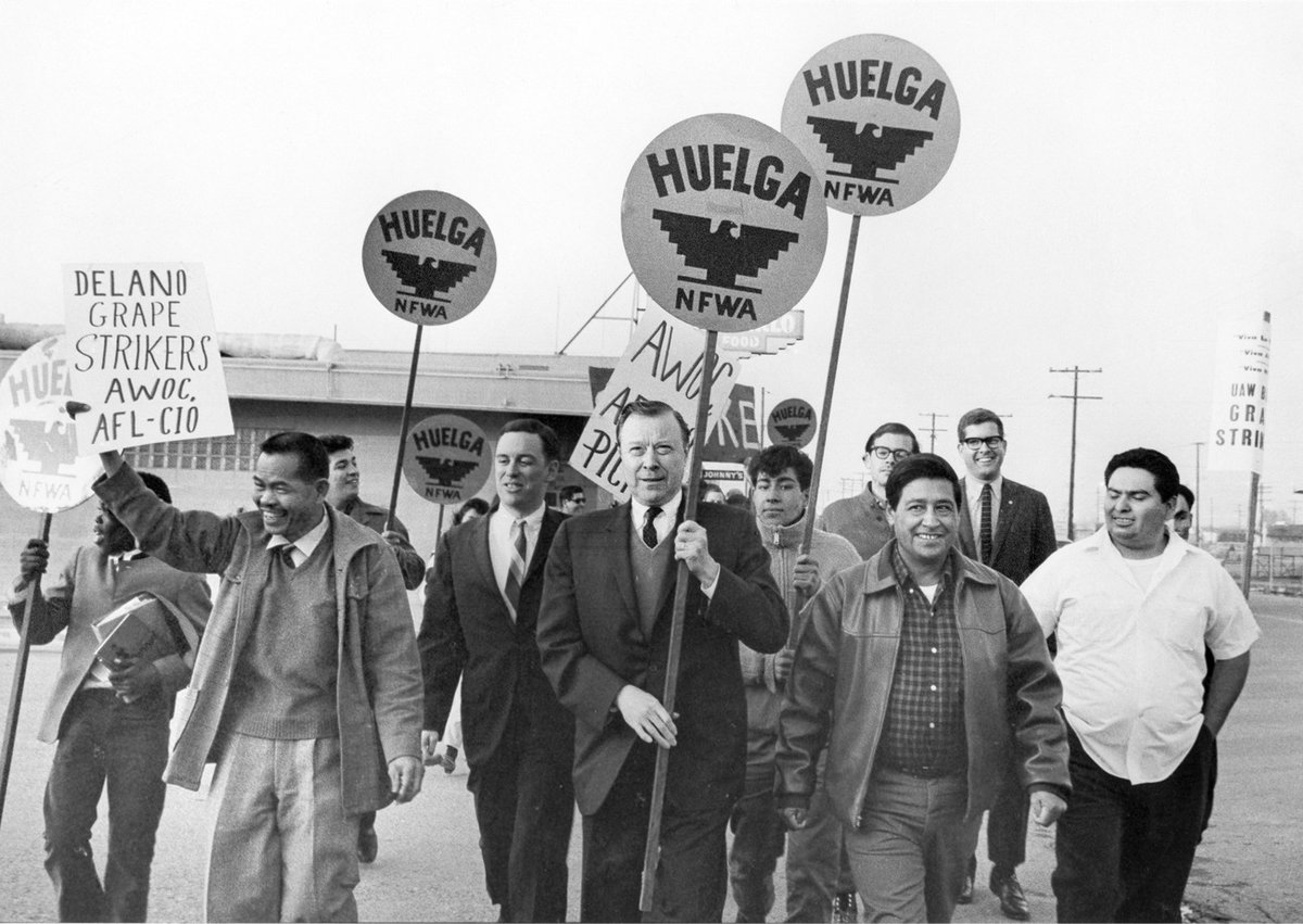 a black and white of a group of men carrying signs and marching during the Delano Grape Strike