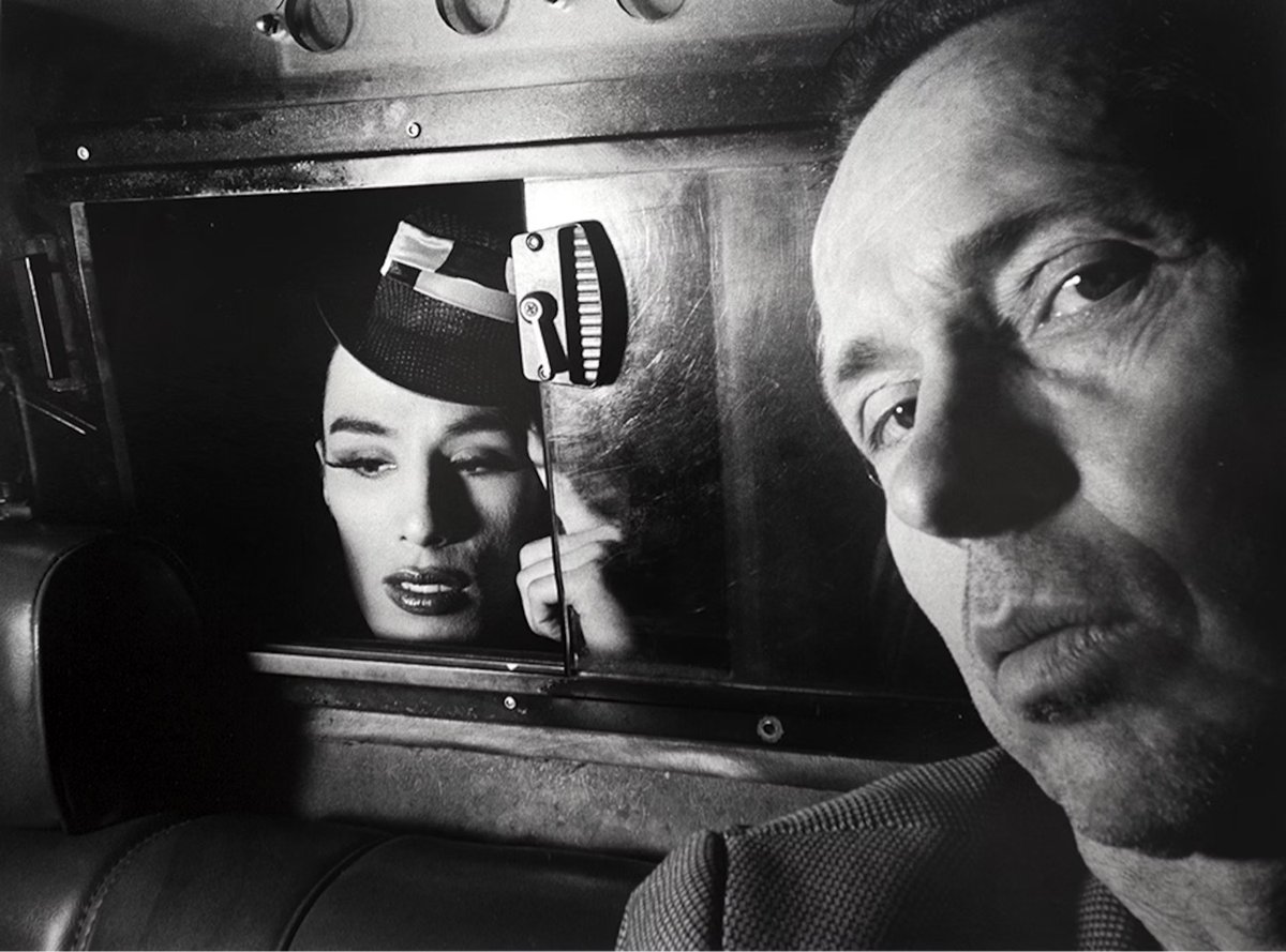 woman in the back on a taxi cab peeking through the window