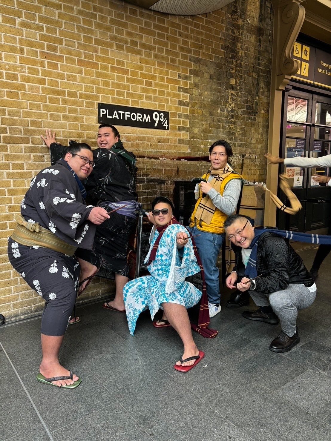 group of sumo wrestlers posing on Platform 9 3/4