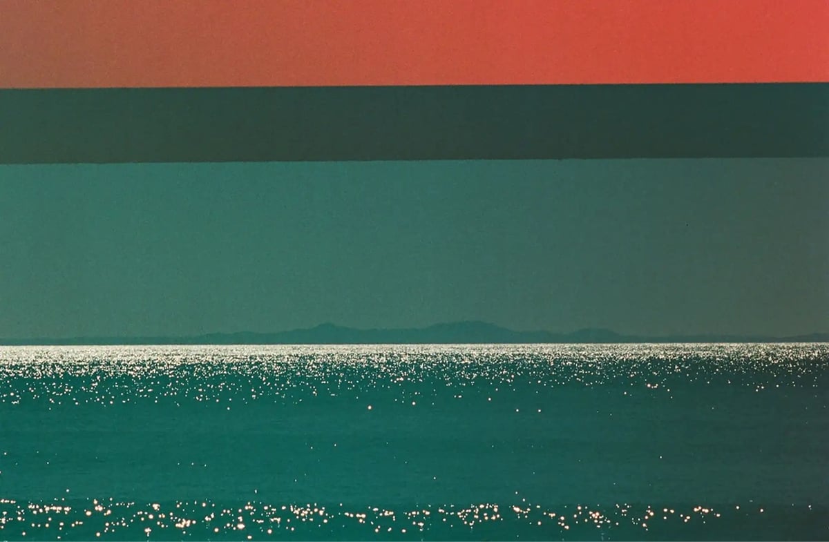 photo of the sun glinting off of the ocean, with a red stripe at the top