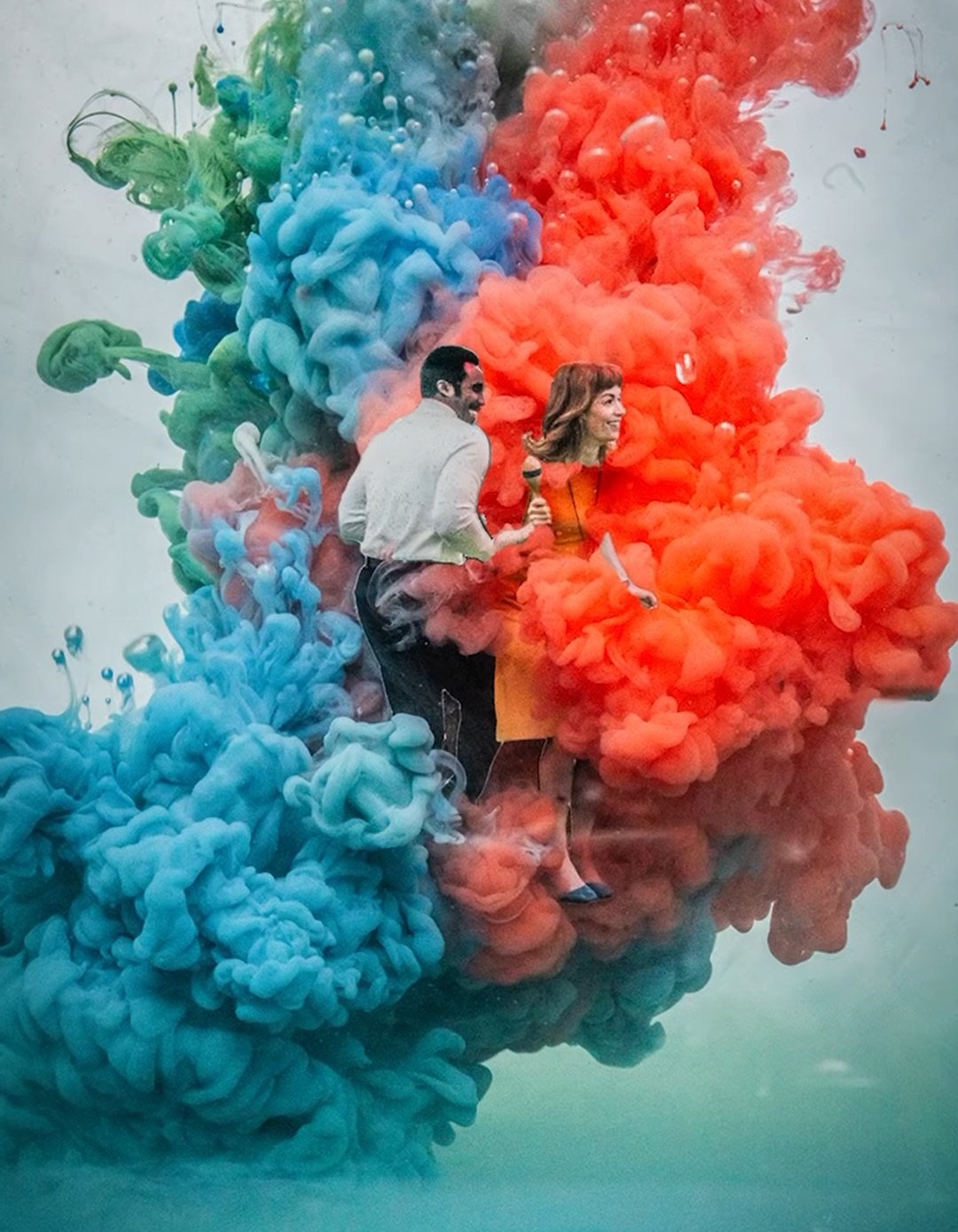 a man and woman dancing are surrounded by multicolored smoke