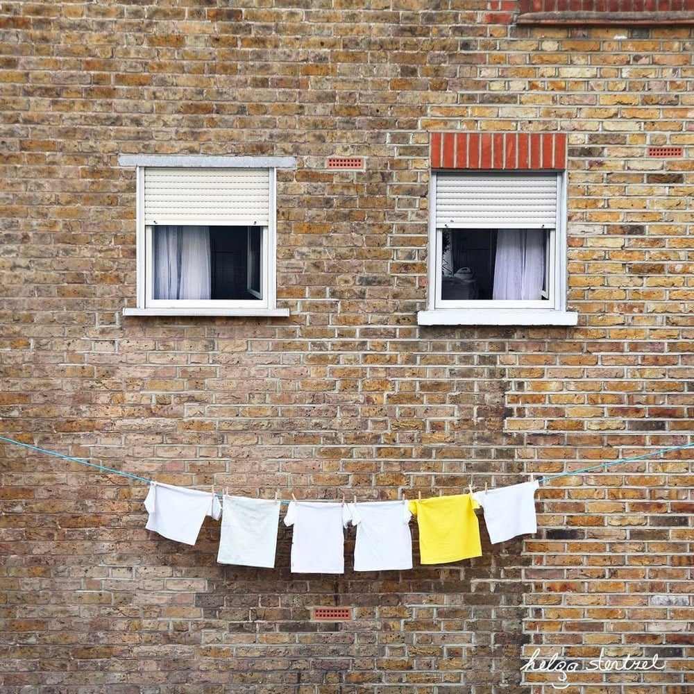 two windows and some hanging laundry that look like a face