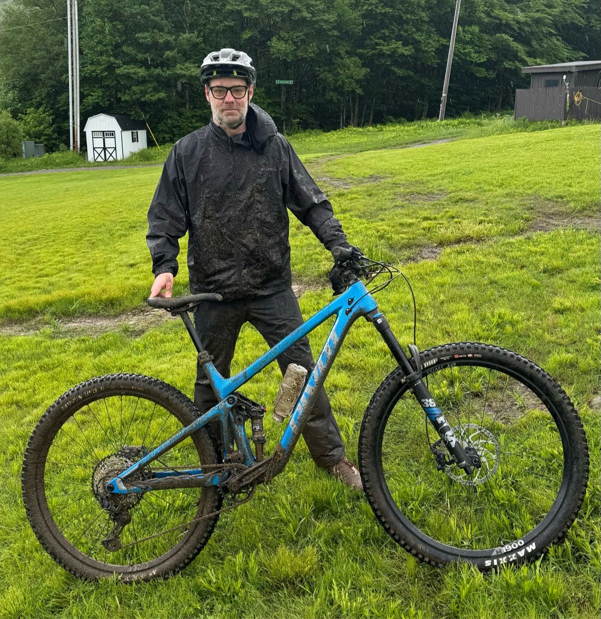 a very muddy Jason posing with his bright blue bike
