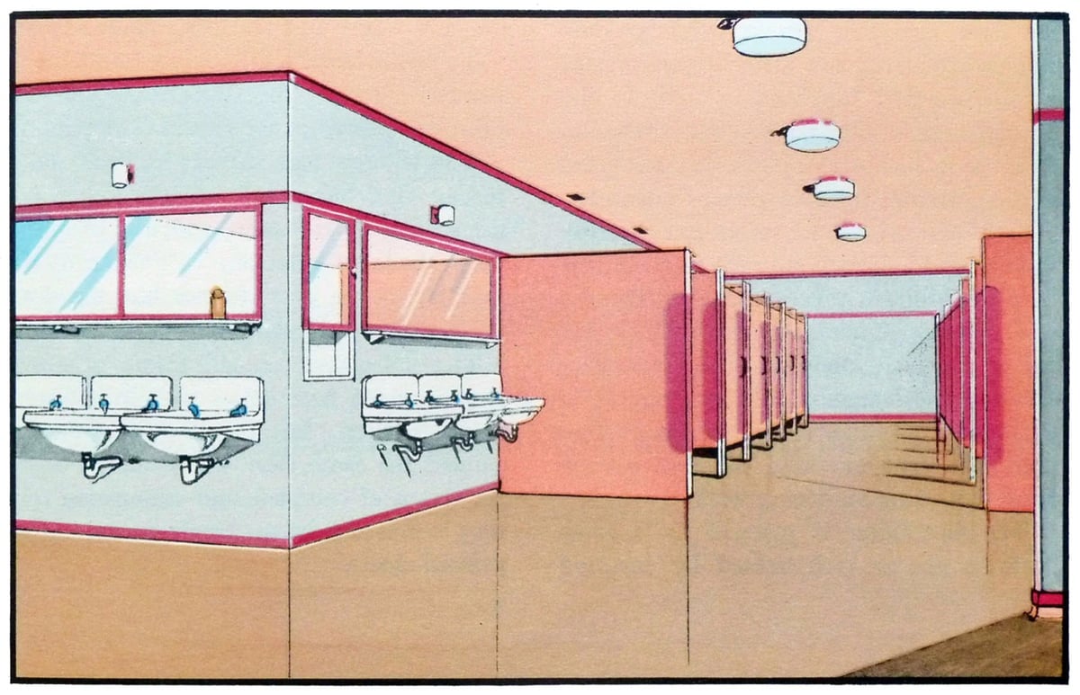 A clean and functional restroom corridor with a series of sinks and stall doors in salmon pink, contrasted with a cool blue floor and natural light filtering through the windows.
