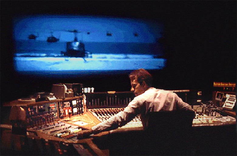 a sound designer at a mixing board scoring a film