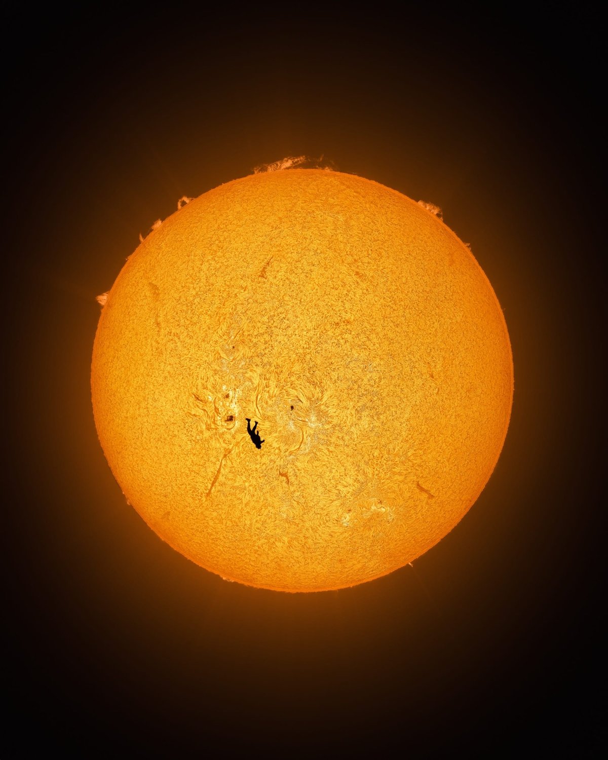 a skydiver's silhouette on the whole sun