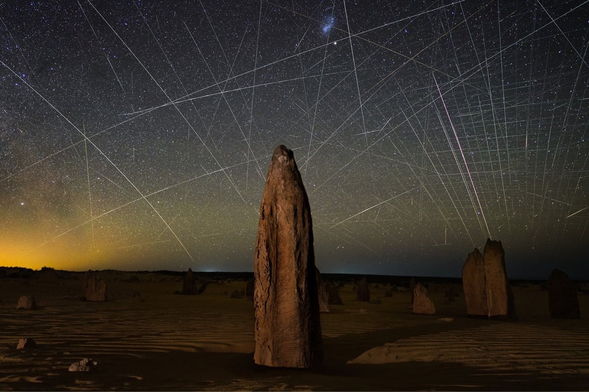 a photo of a night sky with dozens of satellite trails