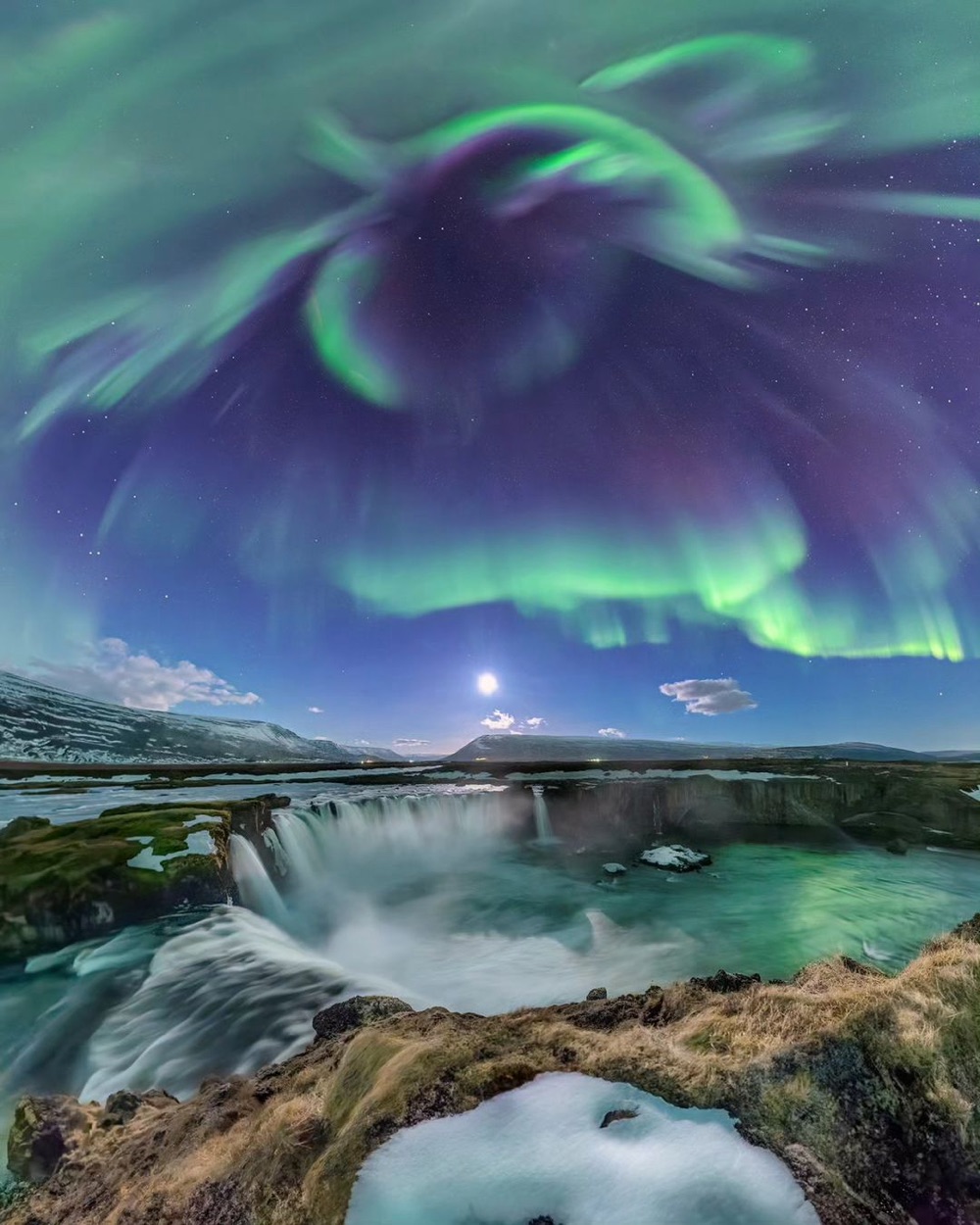 the aurora borealis in the sky over an Icelandic waterfall