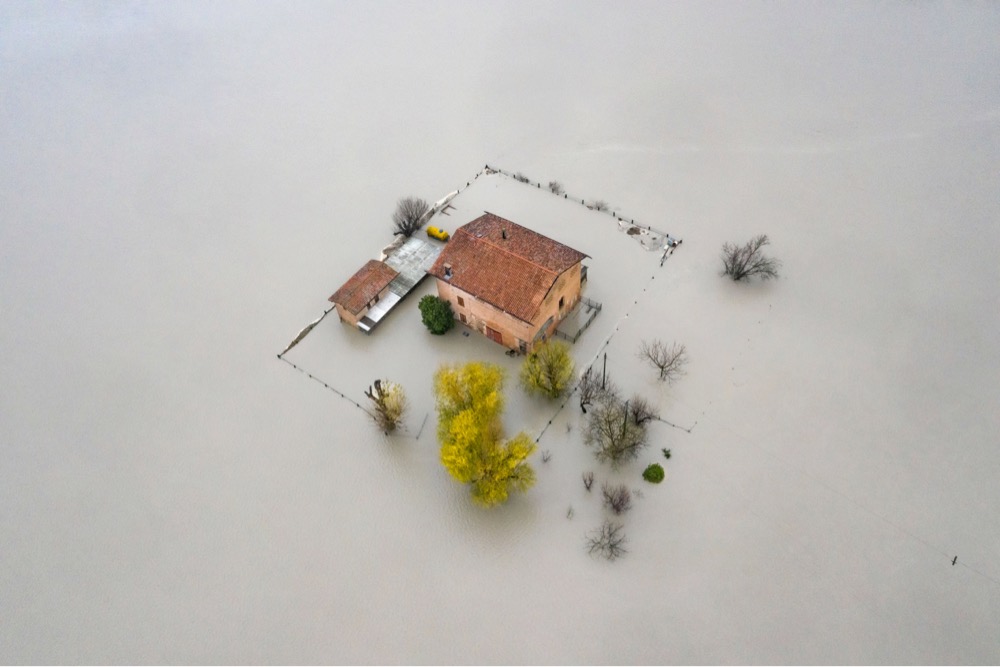 an overhead view of a house surrounded by flood waters