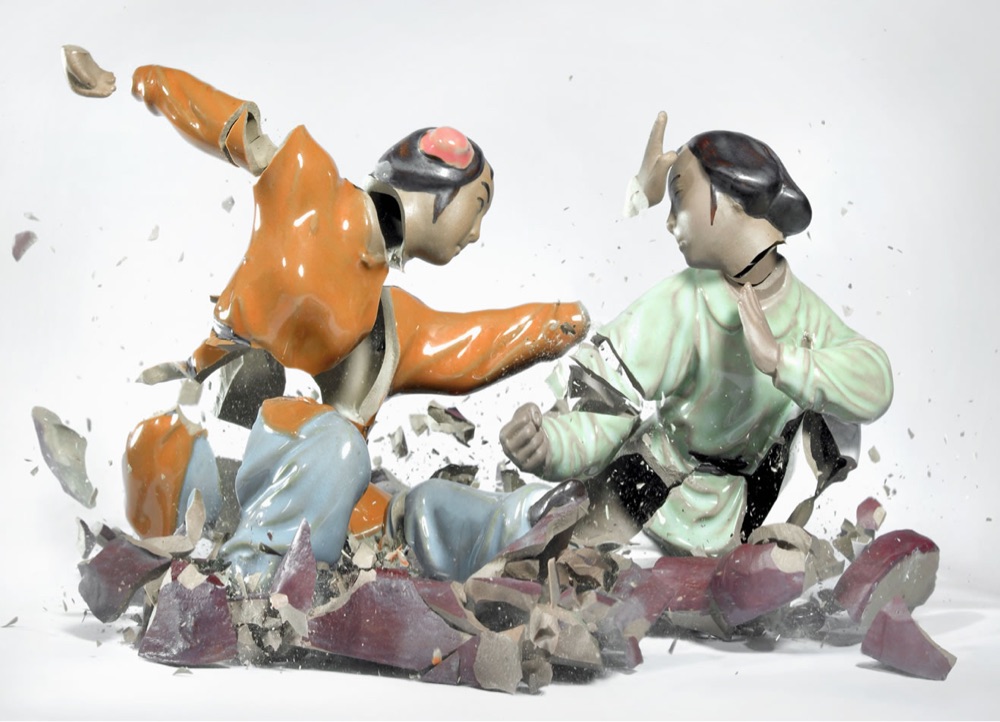 a pair of shattering porcelain statues caught a fraction of a second after hitting the floor
