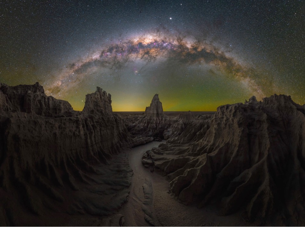 a photo of the Milky Way galaxy over a rocky canyon