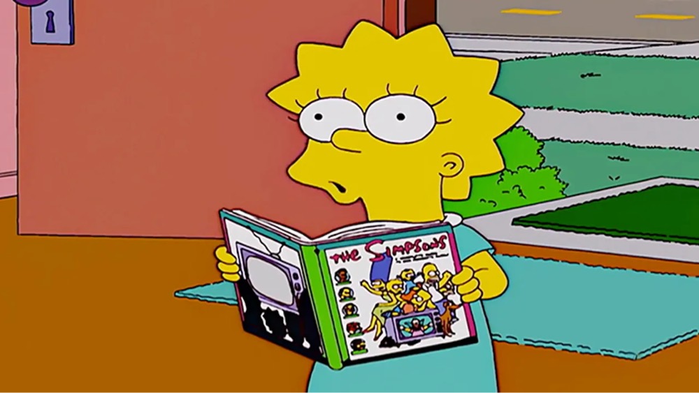 Lisa Simpson holding a book about The Simpsons